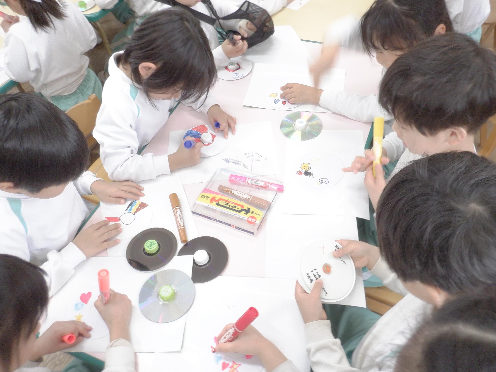 子ども達がCDゴマを工作している様子です
