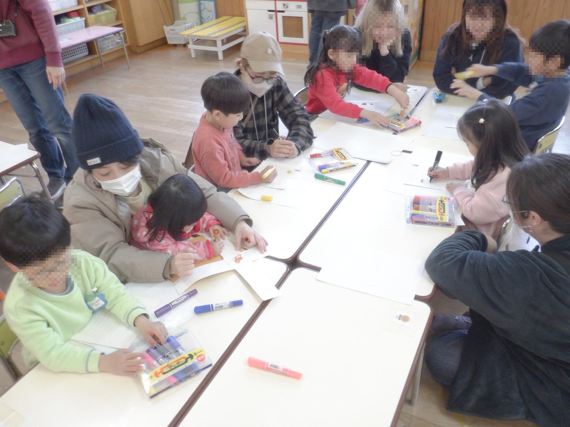 子ども達が保護者と一緒に牛乳パックブーメランを工作している様子です