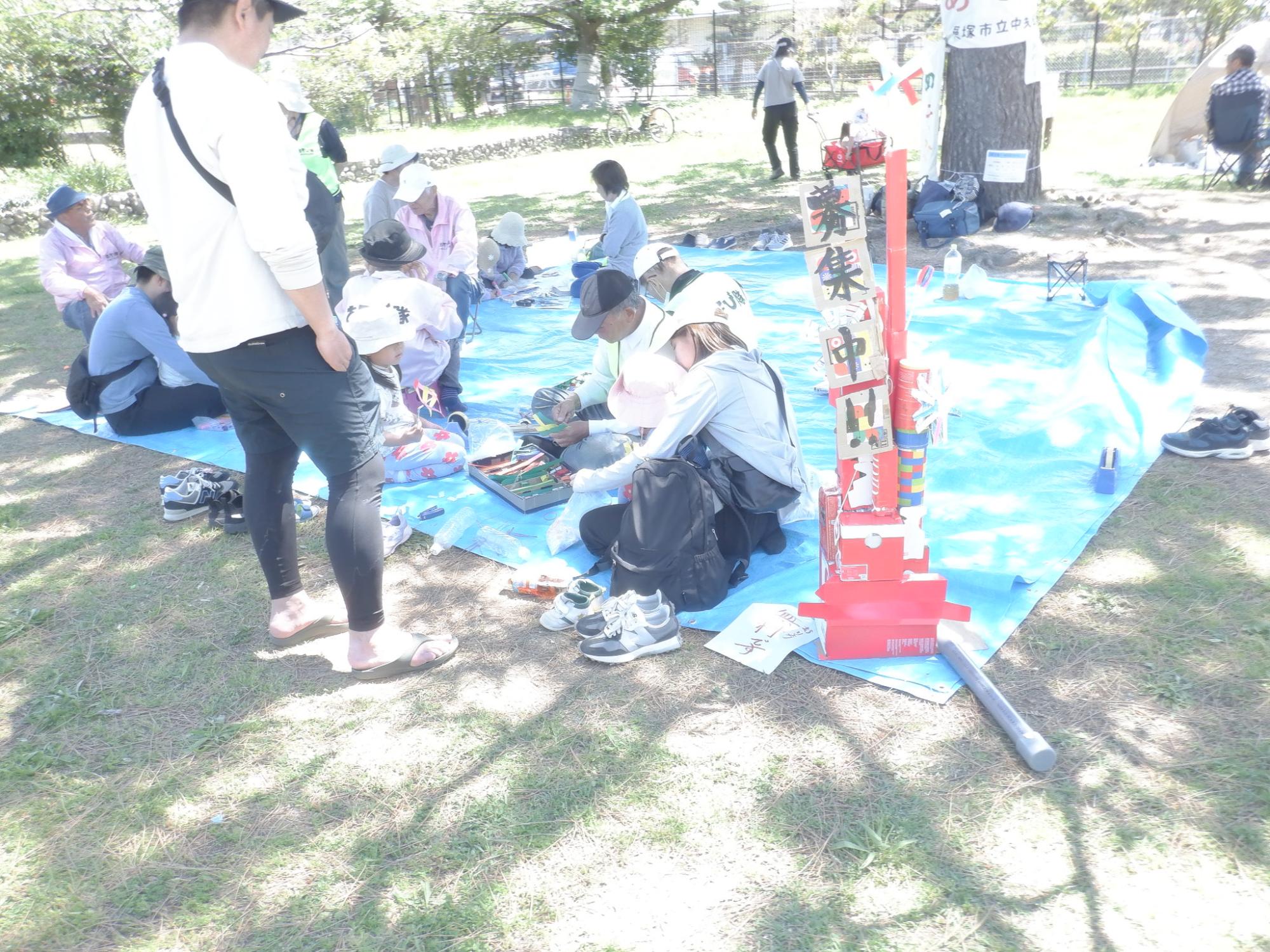 二色の浜公園で子ども達や親子がおもちゃ作りをしている様子です