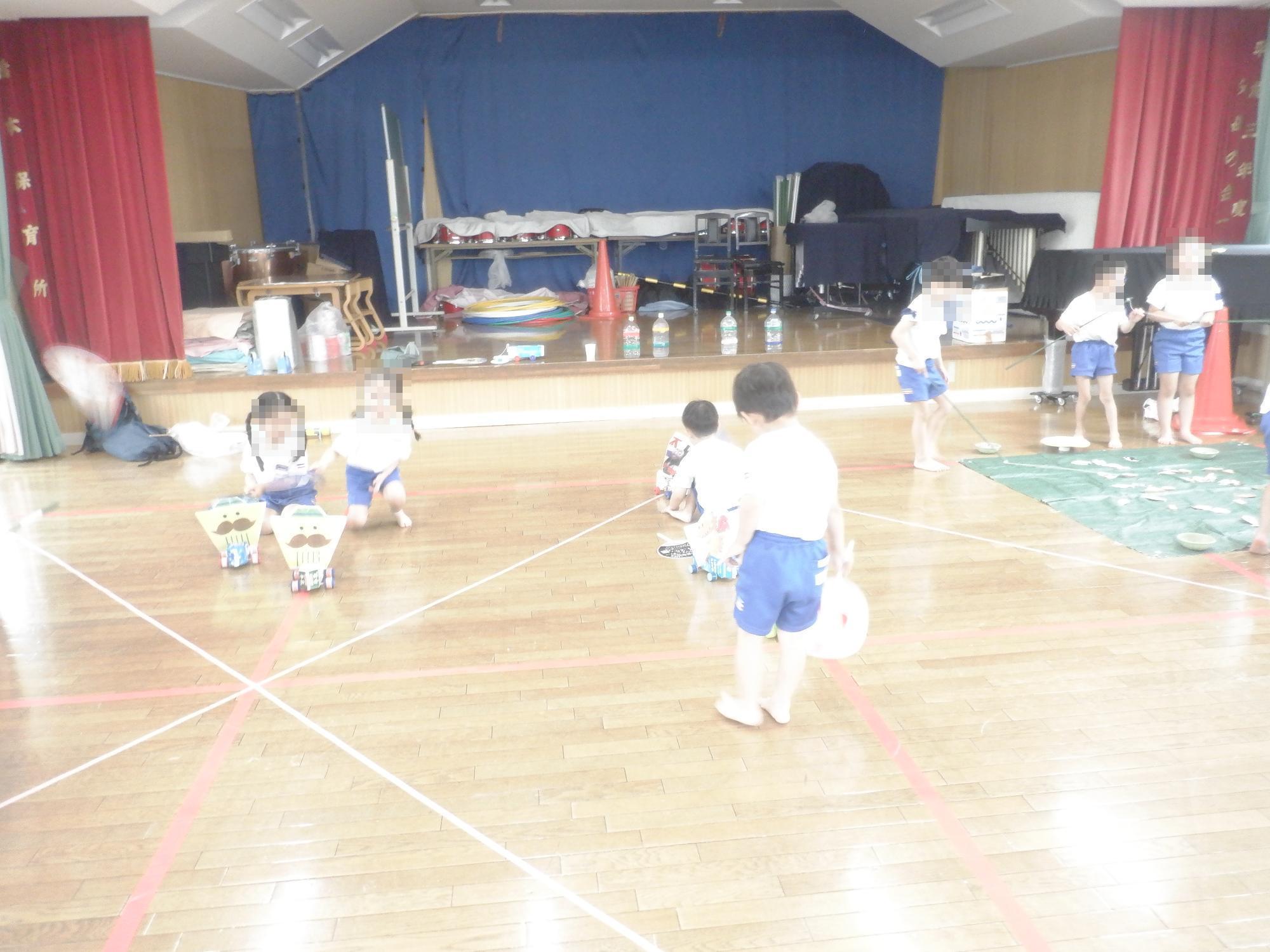 子ども達がうちわ自動車を走らせている様子です