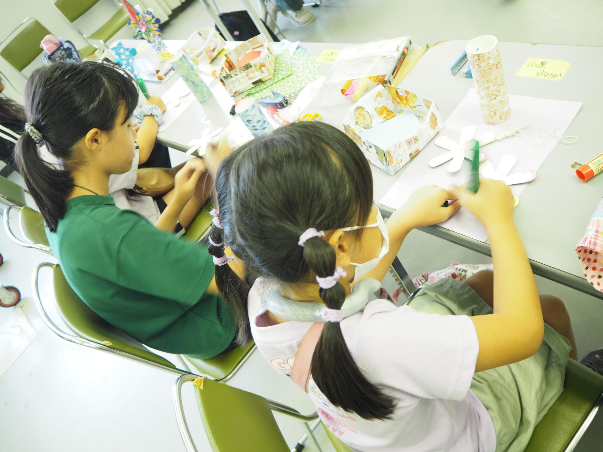 子どもが風車に色をぬっている様子