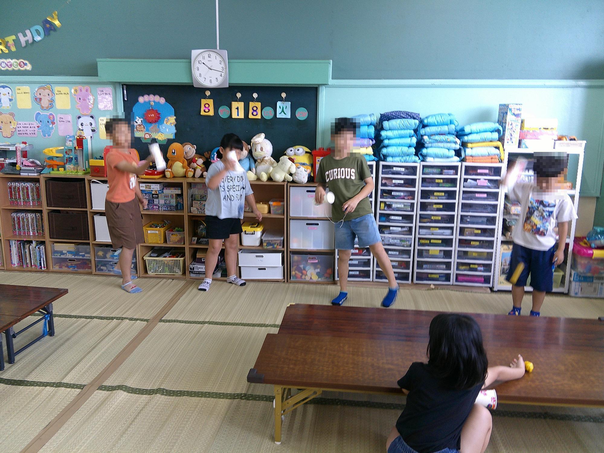 子ども達が紙コップけん玉で遊んでいる様子です