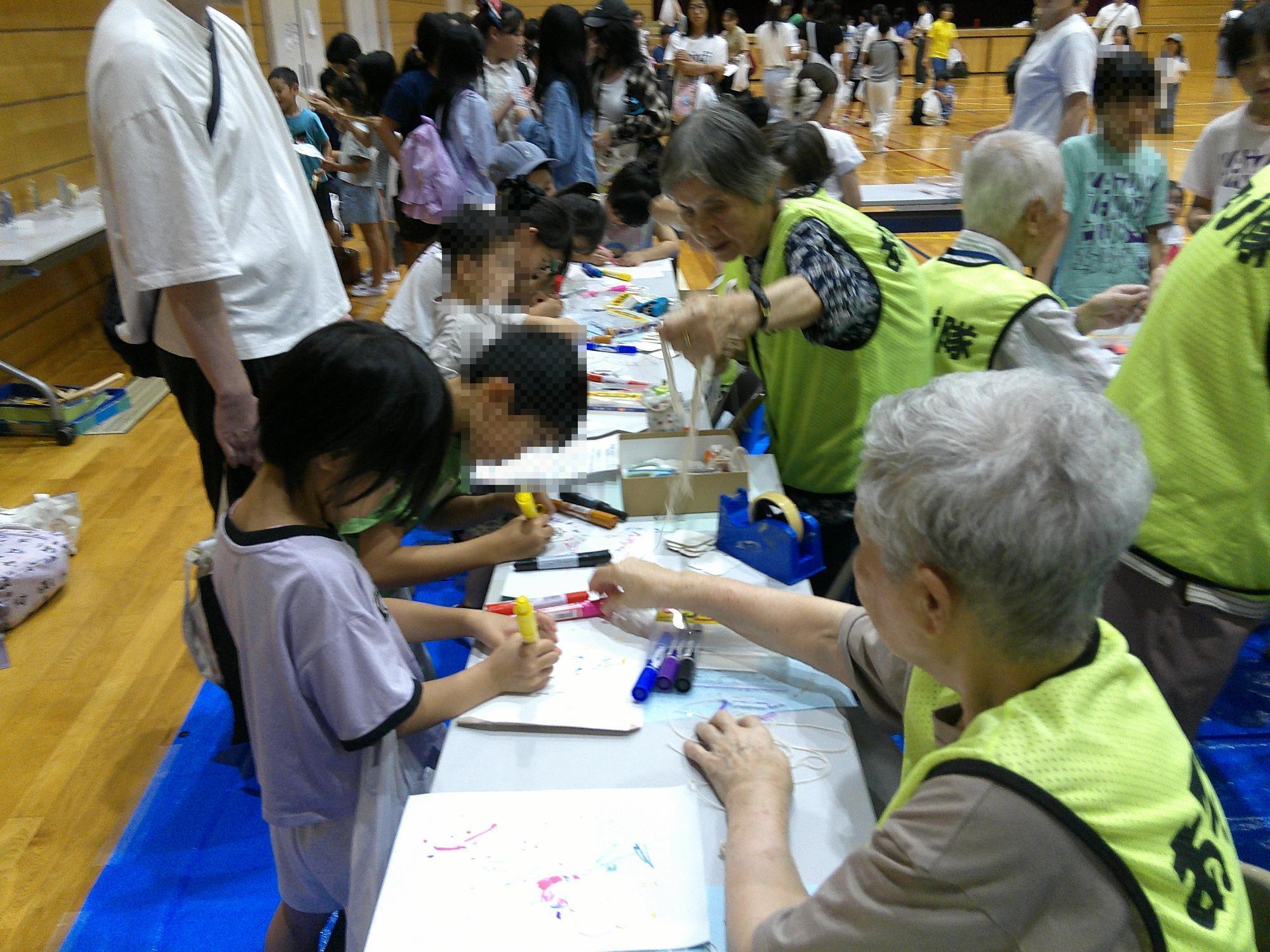 子ども達がブンブンゴマを製作している様子です