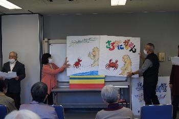 紙芝居の様子です  大きな紙芝居に「さるかにがっせん」の文字と、猿と蟹の絵が描かれています