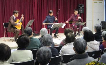 二胡とギターの演奏に観客が聴き入っています。