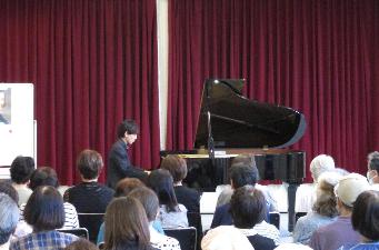 宮原雄大さんがグランドピアノを演奏し、会場の皆さんが聴き入っています
