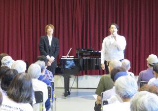 テノール歌手の佐々木涼輔さんとピアニストの岸元大周さんが客席の方を向いてトークをしています