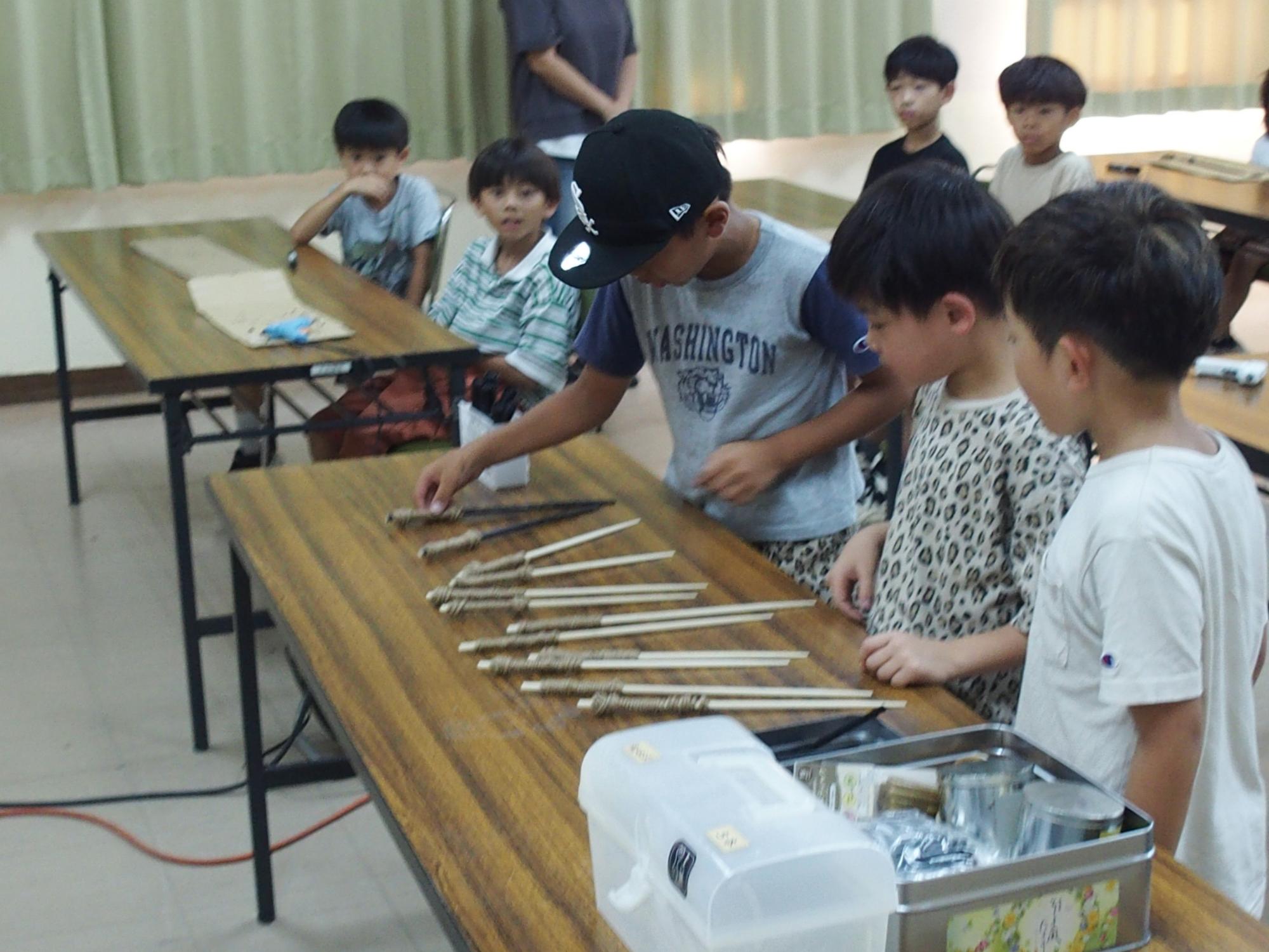 工作活動（子どもたちが施設で使わなくなった菜箸を使って、工作をしています。）