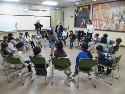 子どもが輪になって椅子に座りフルーツバスケットをしている様子