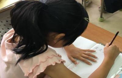 子どもが硬筆講座でノートに字を書く練習をしている様子