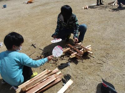 高学年活動で焚火体験をするために子どもたちが焚火用の木を組んでいる様子