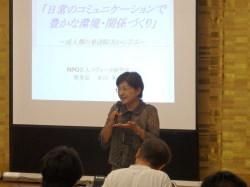 スクリーンの前で講演する米田さん