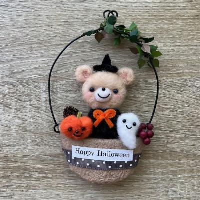 羊毛フェルトで作られた、カボチャやゴーストと一緒に座っている可愛らしいクマのハロウィン壁飾り