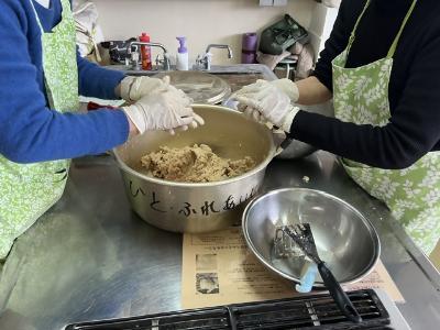 大きなボールを囲んで手作りみその仕込みの作業をしている様子