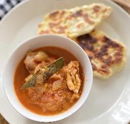 容器に盛られたチキンカレーと手作りのナン