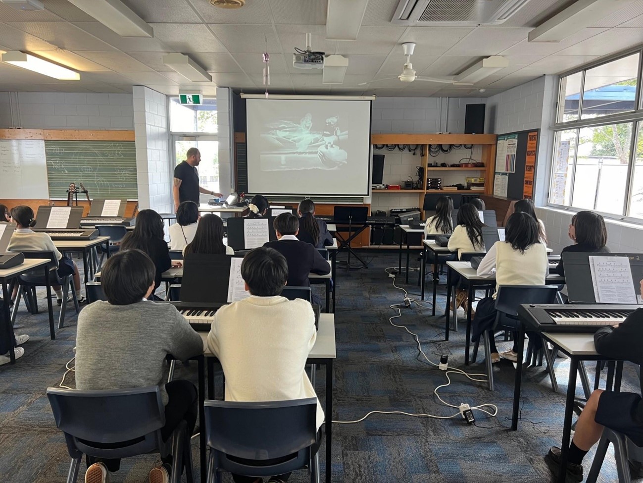 カルバーシティ市の学校にて、現地の学生とともに音楽の授業体験を受けている様子です。