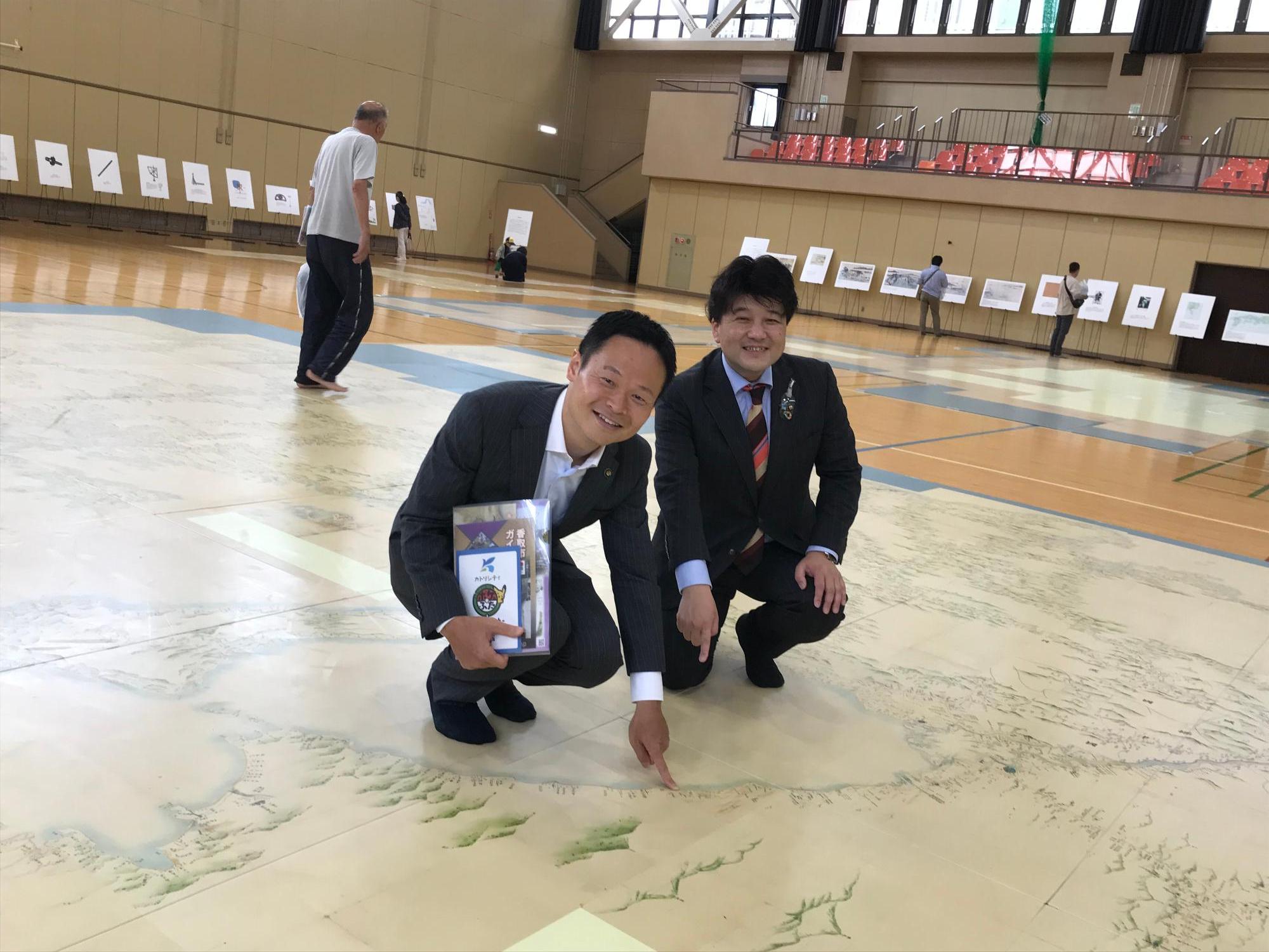 伊藤香取市長と地図上で記念撮影を行う酒井市長