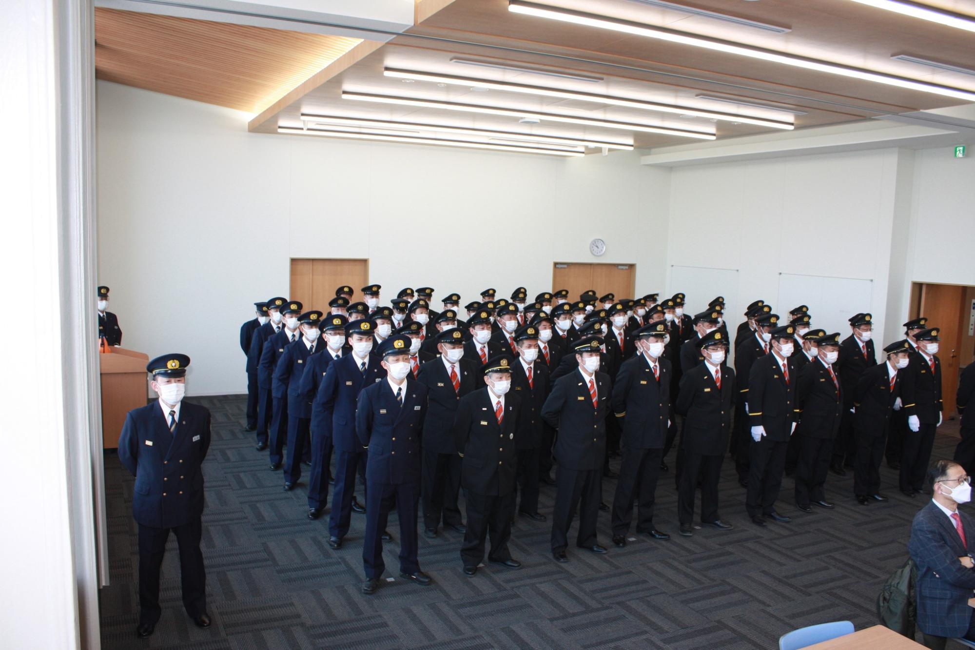 市役所多目的ホールで整列する消防団員