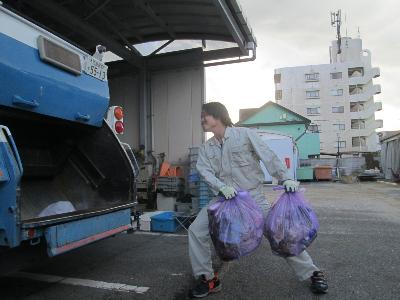清掃員がパッカー車にごみを投入する様子です。