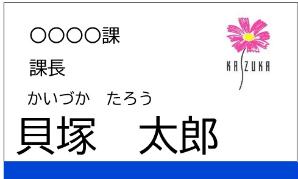 変更前の名札のイメージです。右上にコスモスマークが示され、課名・役職・氏名のふりがなと漢字を表記しています。