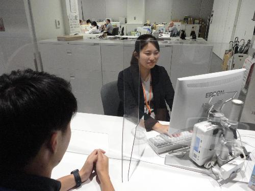 職員が窓口カウンターに座って市民を対応する様子です。