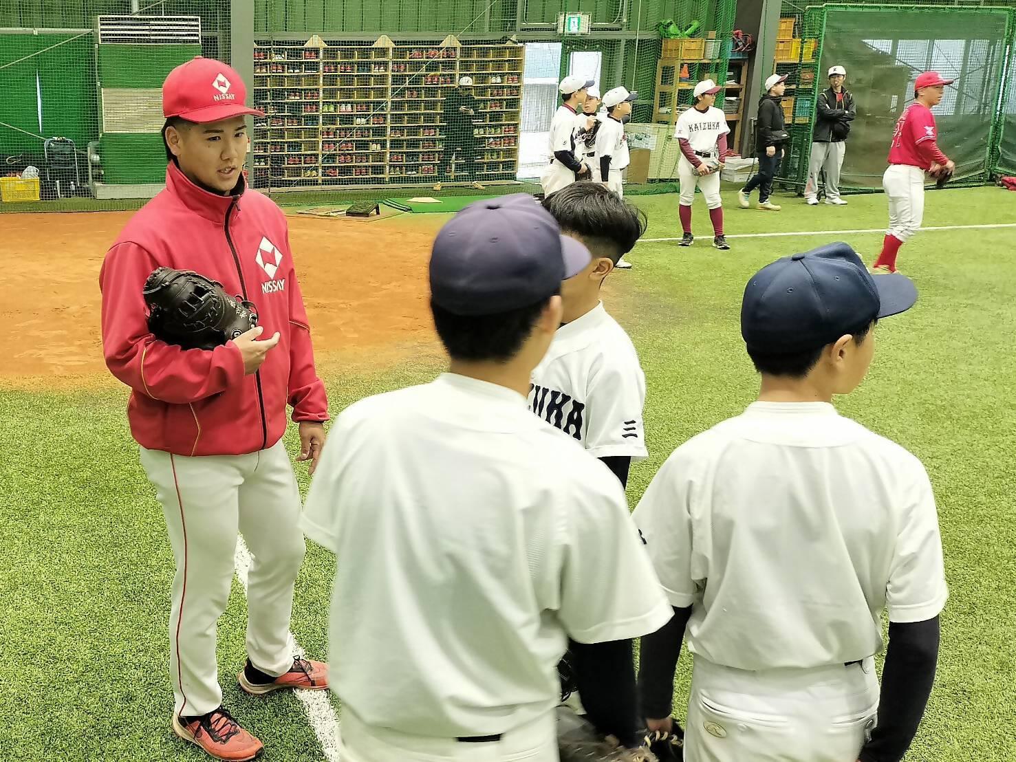 室内練習場で日本生命の選手から中学生へアドバイスしている様子