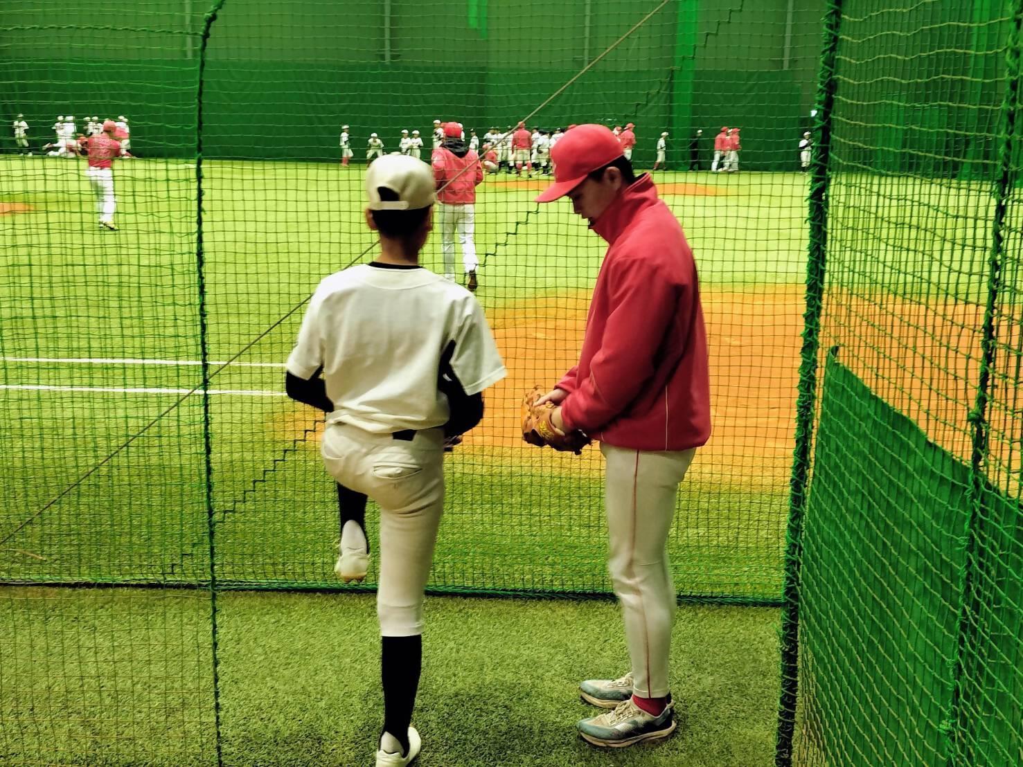 室内練習場で日本生命の選手が一対一で中学生へアドバイスしている様子