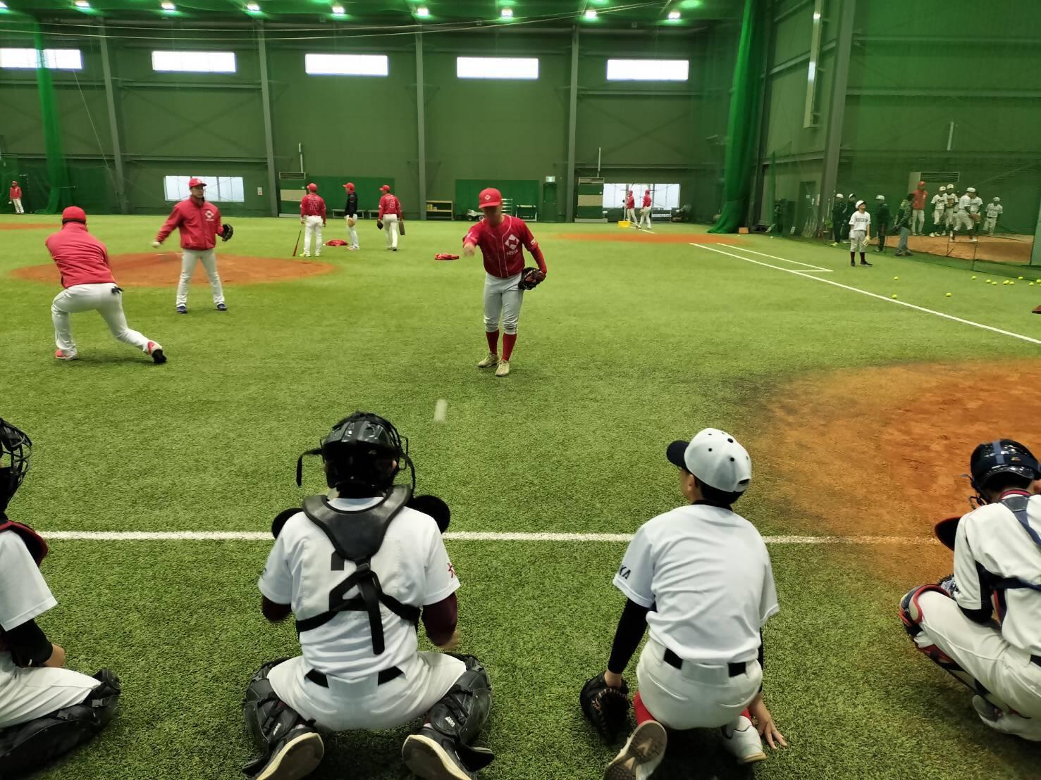 室内練習場で日本生命の選手がキャッチャーの指導している様子