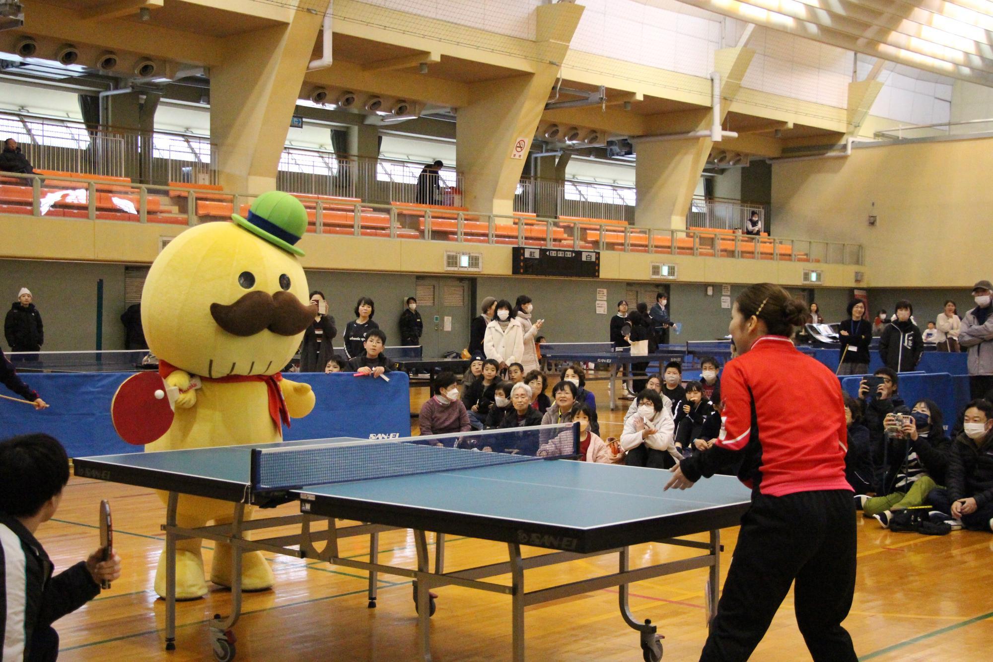 貝塚卓球フェスティバルで日本生命レッドエルフの選手とつげさんがラリーをしている様子