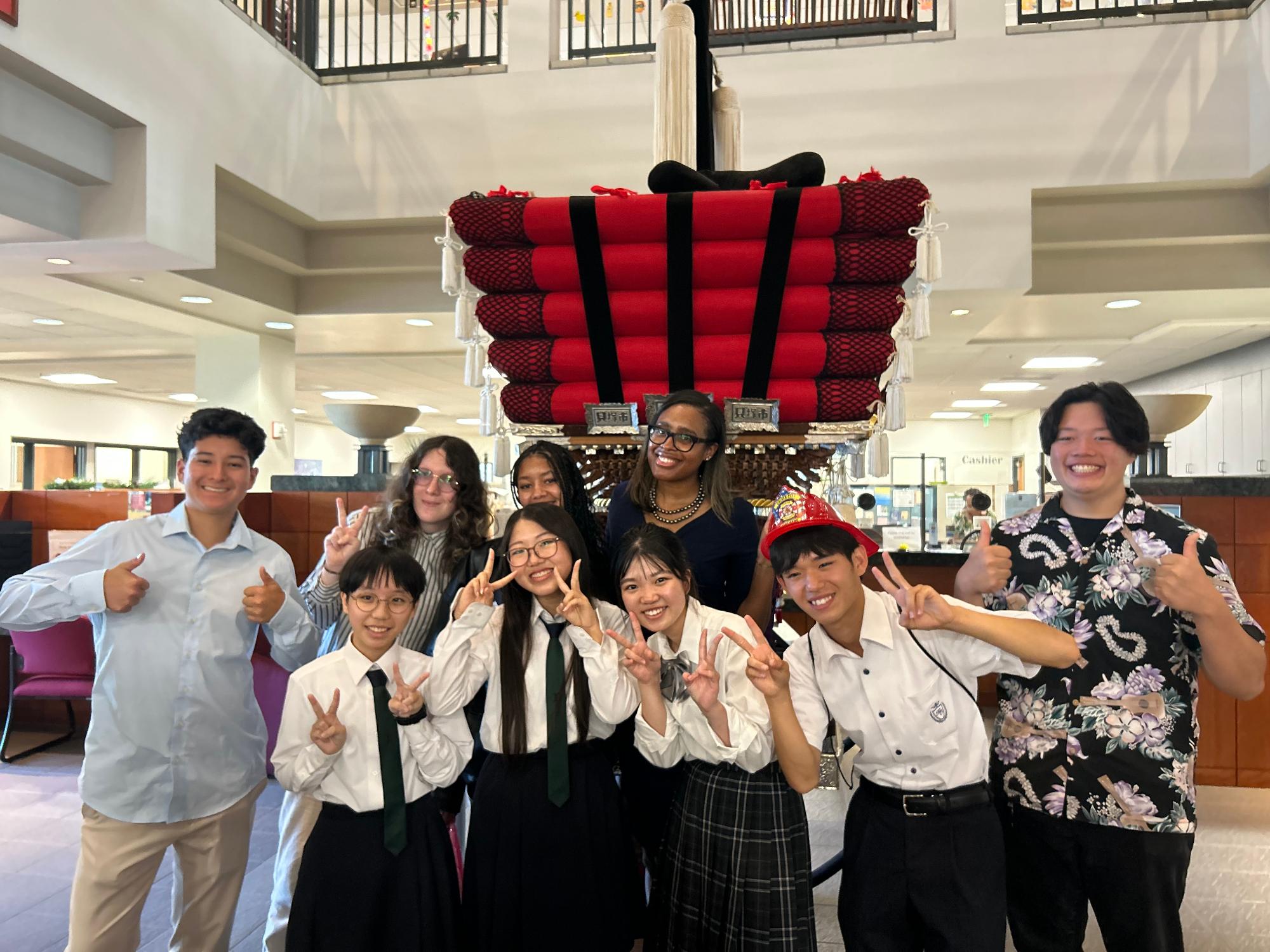 カルバーシティ市役所玄関ホールにある太鼓台の前で市長と高校生達がならんで撮っている記念写真。
