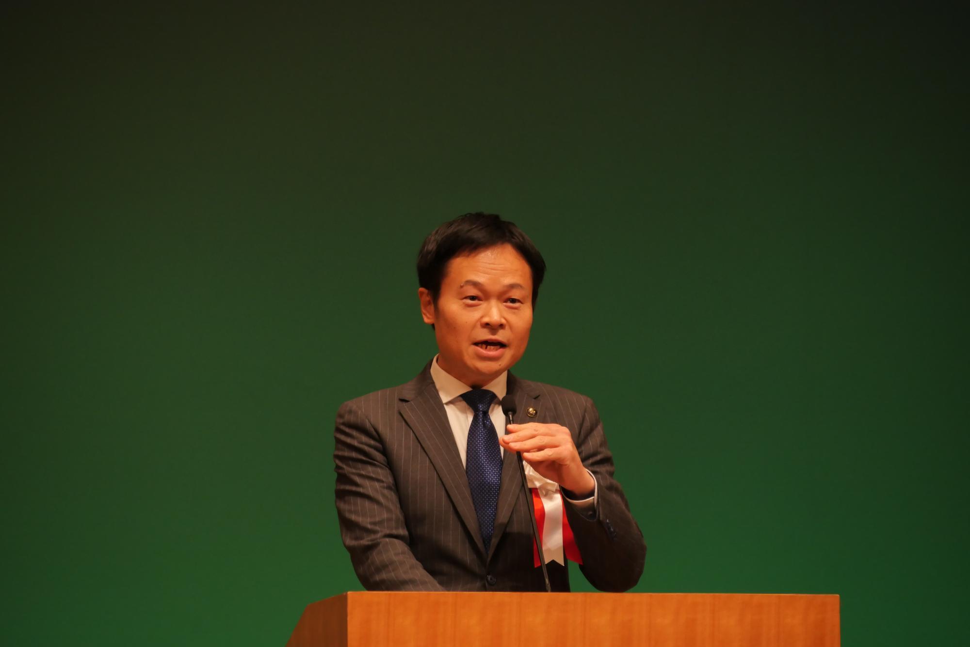 コスモスシアター大ホール舞台上にて市長があいさつをしている様子