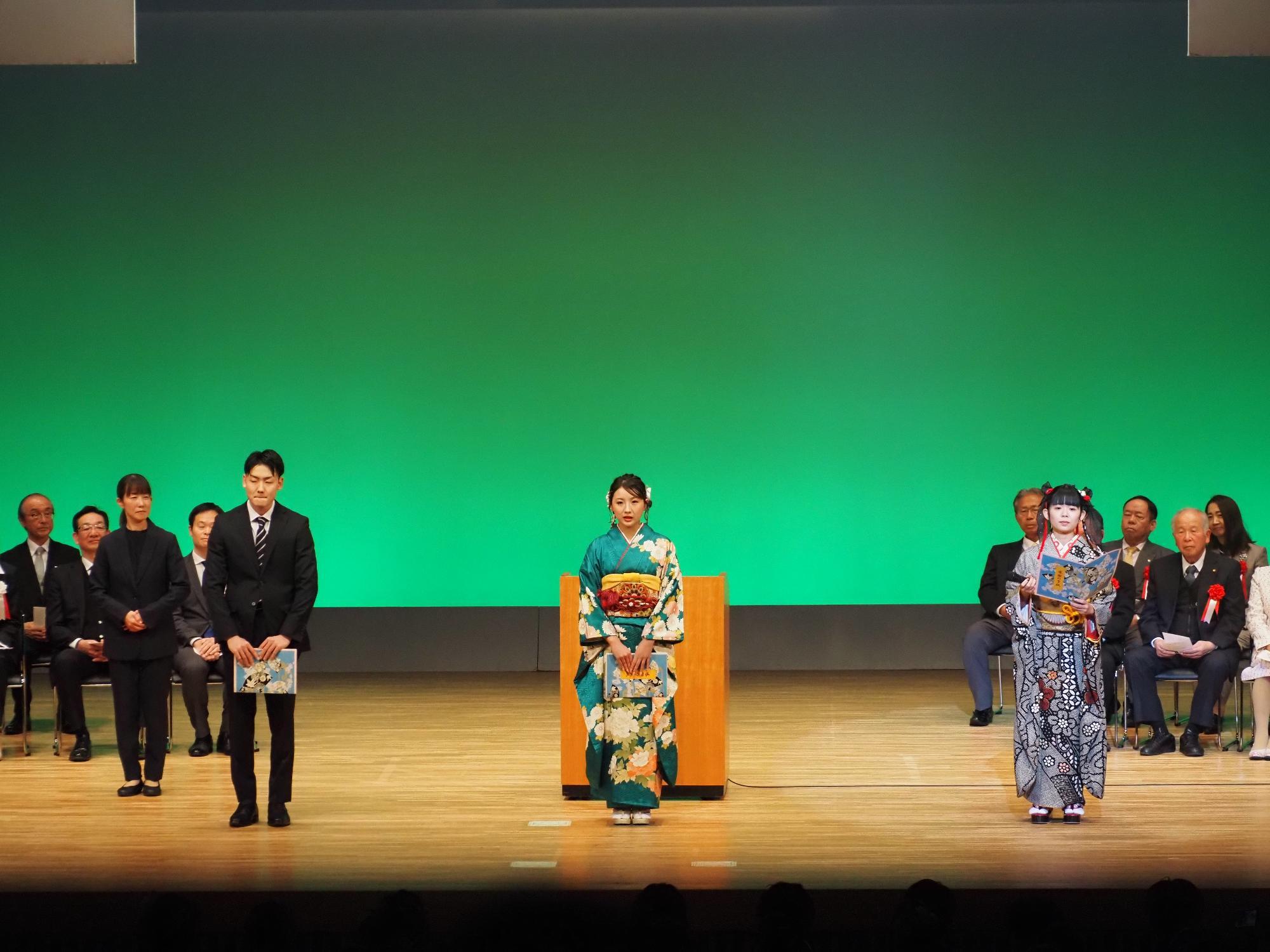 はたちの集いの第1部の式典の中で、第三中学校から第五中学校の各代3人が感謝の手紙を読むためコスモスシアター大ホール舞台上にて整列している様子