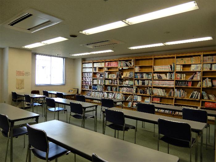 図書室の写真（たくさんの蔵書が並んでいます。自習室の机椅子が並べられています。）