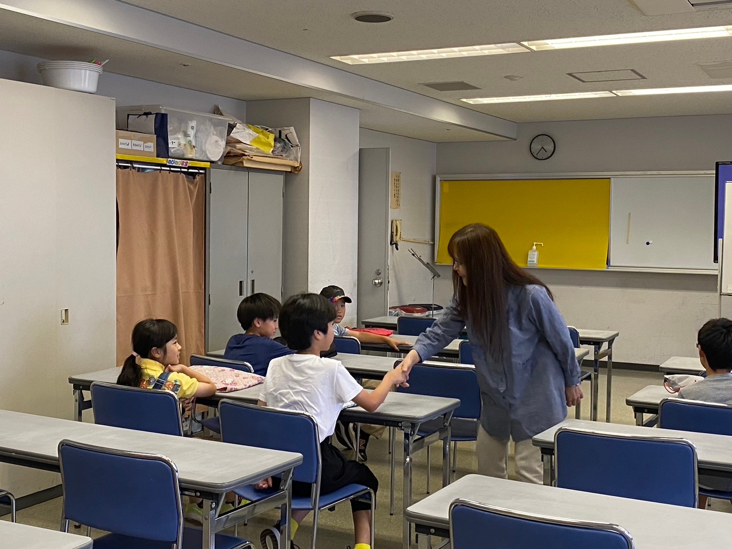 英会話講座であいさつをし、握手している様子