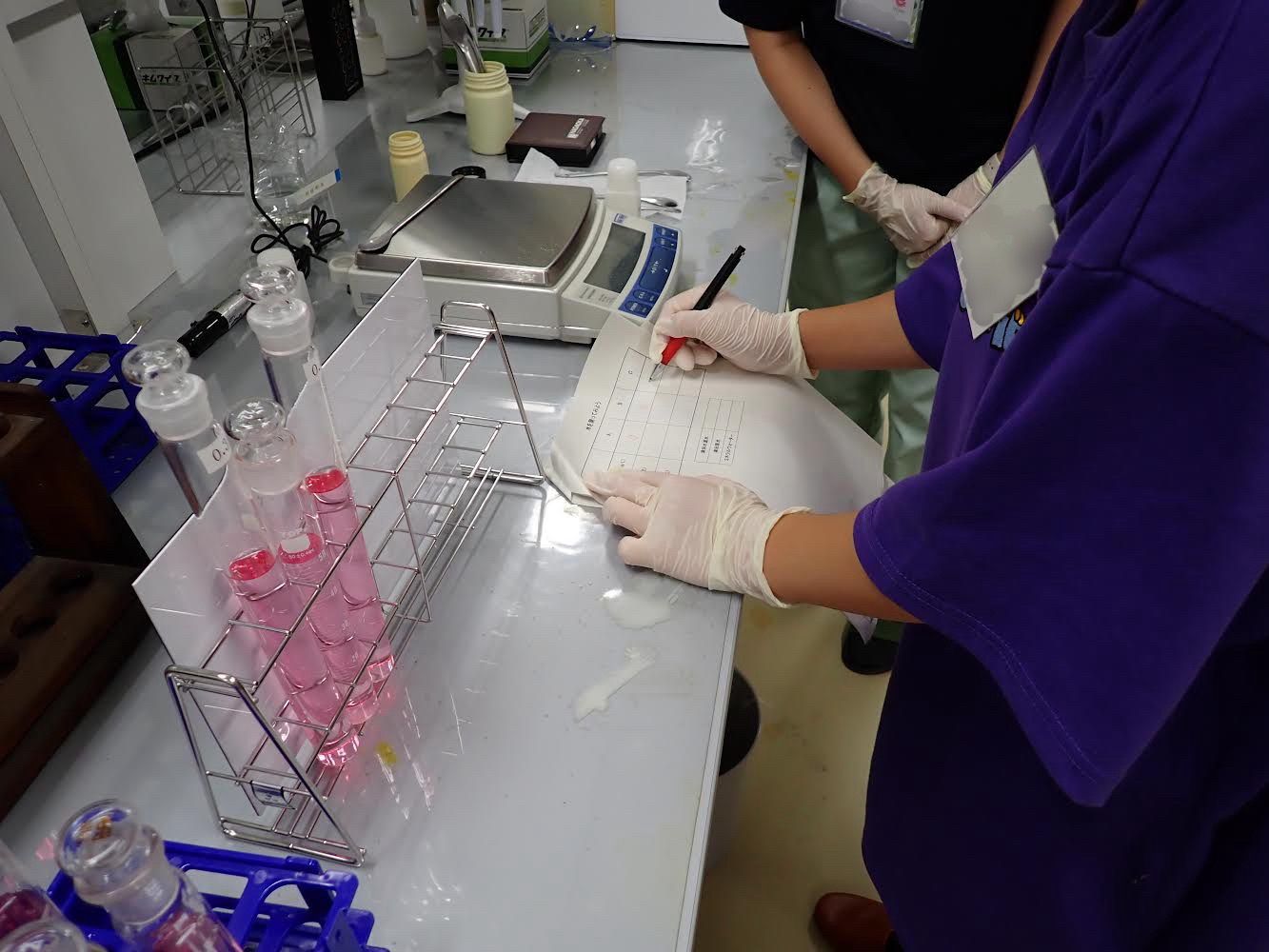 受講生が試験管を使って水質検査を体験している様子