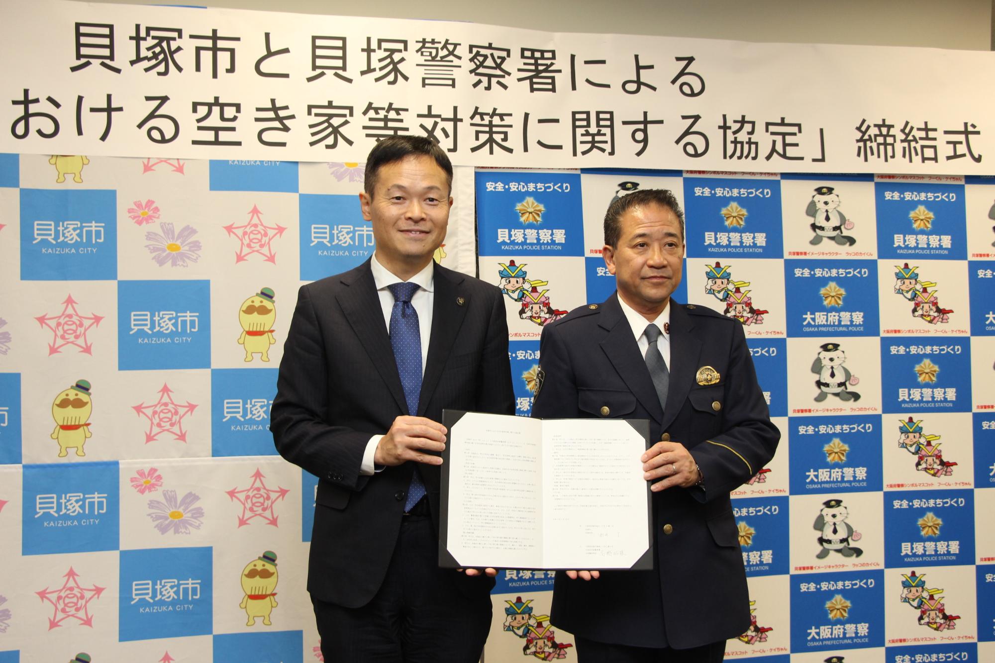 貝塚市長と貝塚警察署長の両名が協定書を持っている様子の写真です