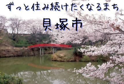 水間公園の桜を映した写真に「ずっと住み続けたくなるまち貝塚市」と表記した画像です。