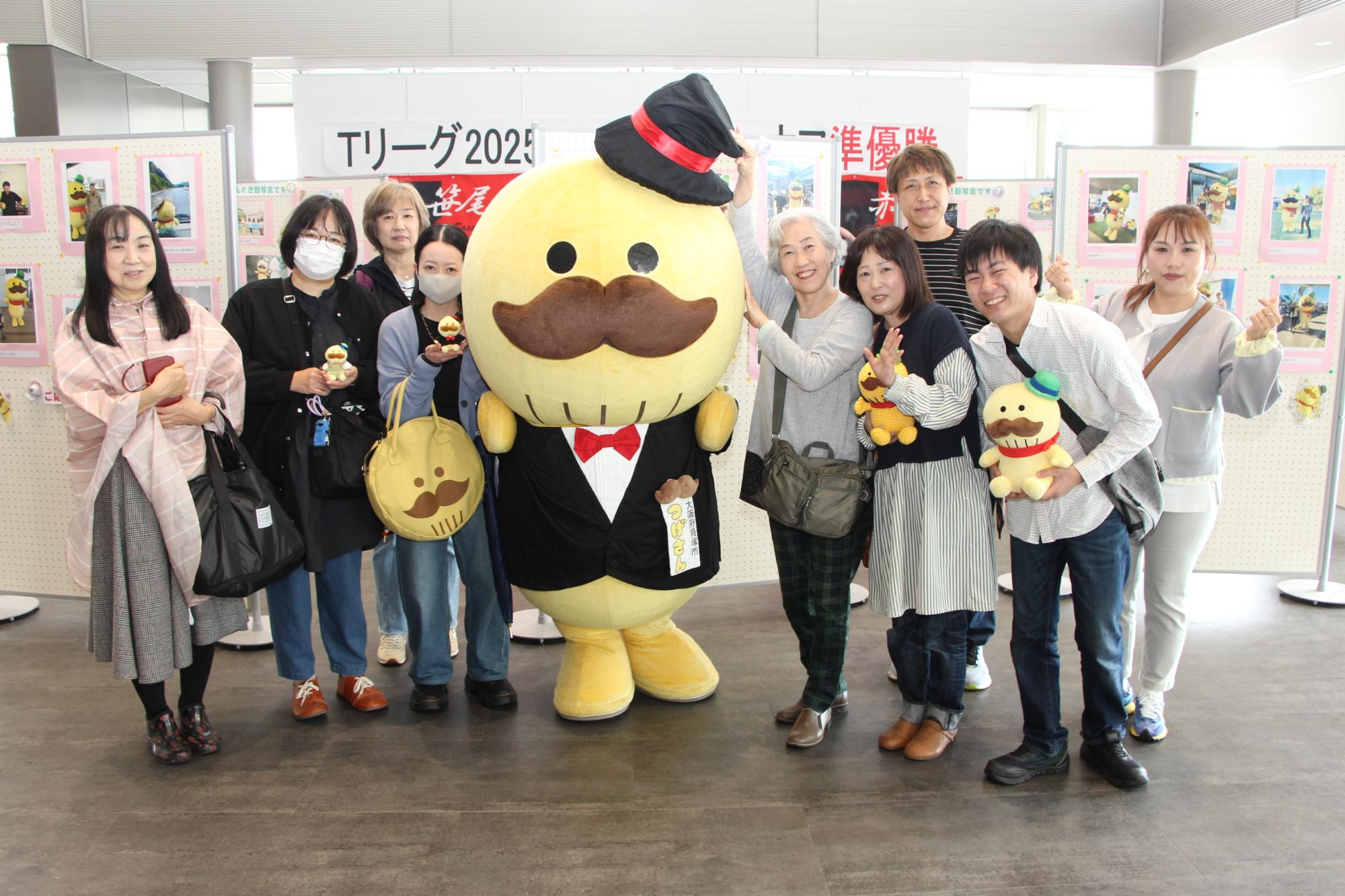 写真展の前でつげさんとファンの皆さんとの記念撮影の写真です