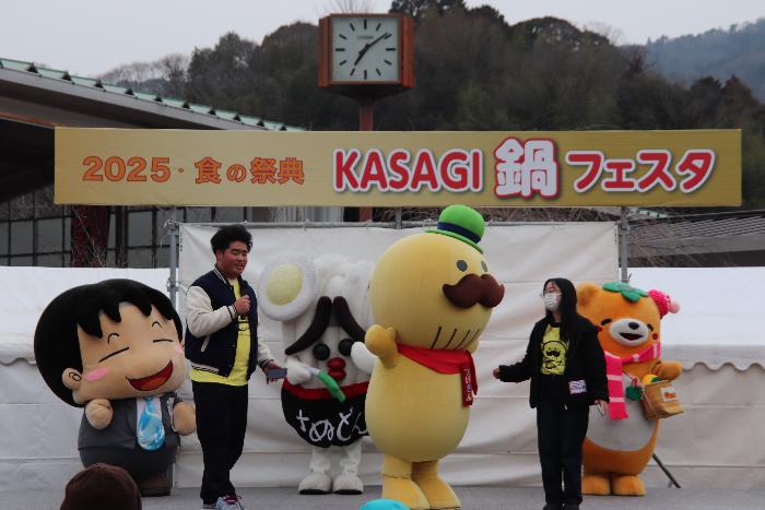 KASAGI鍋フェスタのステージにて学生とつげさんが貝塚市のPRをしている様子