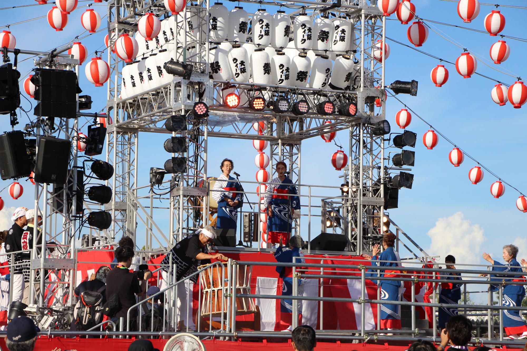 令和7年7月27日の万博会場でのやぐらの上で三夜音頭を披露している様子