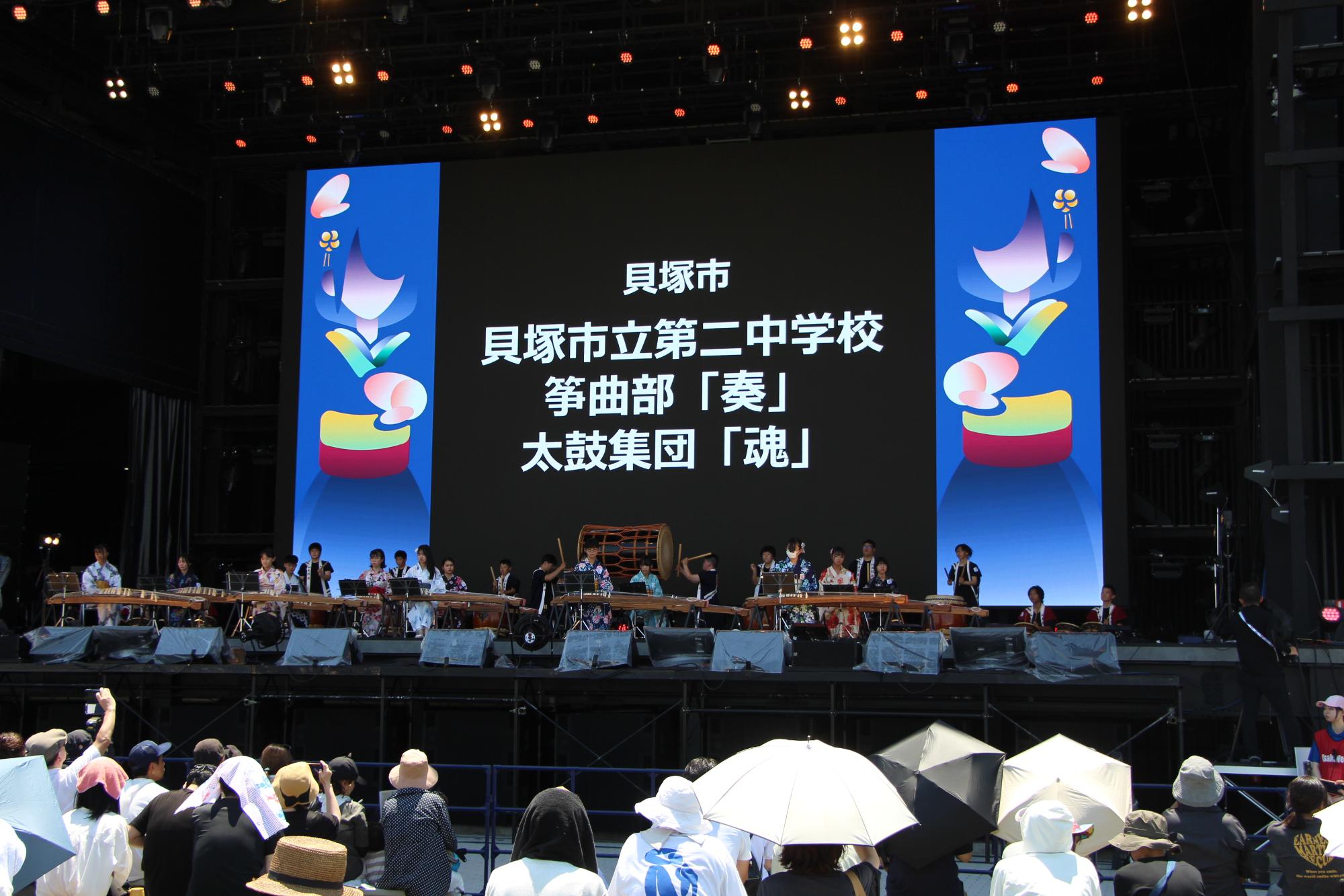 令和7年7月29日の万博会場での第二中学校筝曲部と太鼓集団がステージで披露している様子