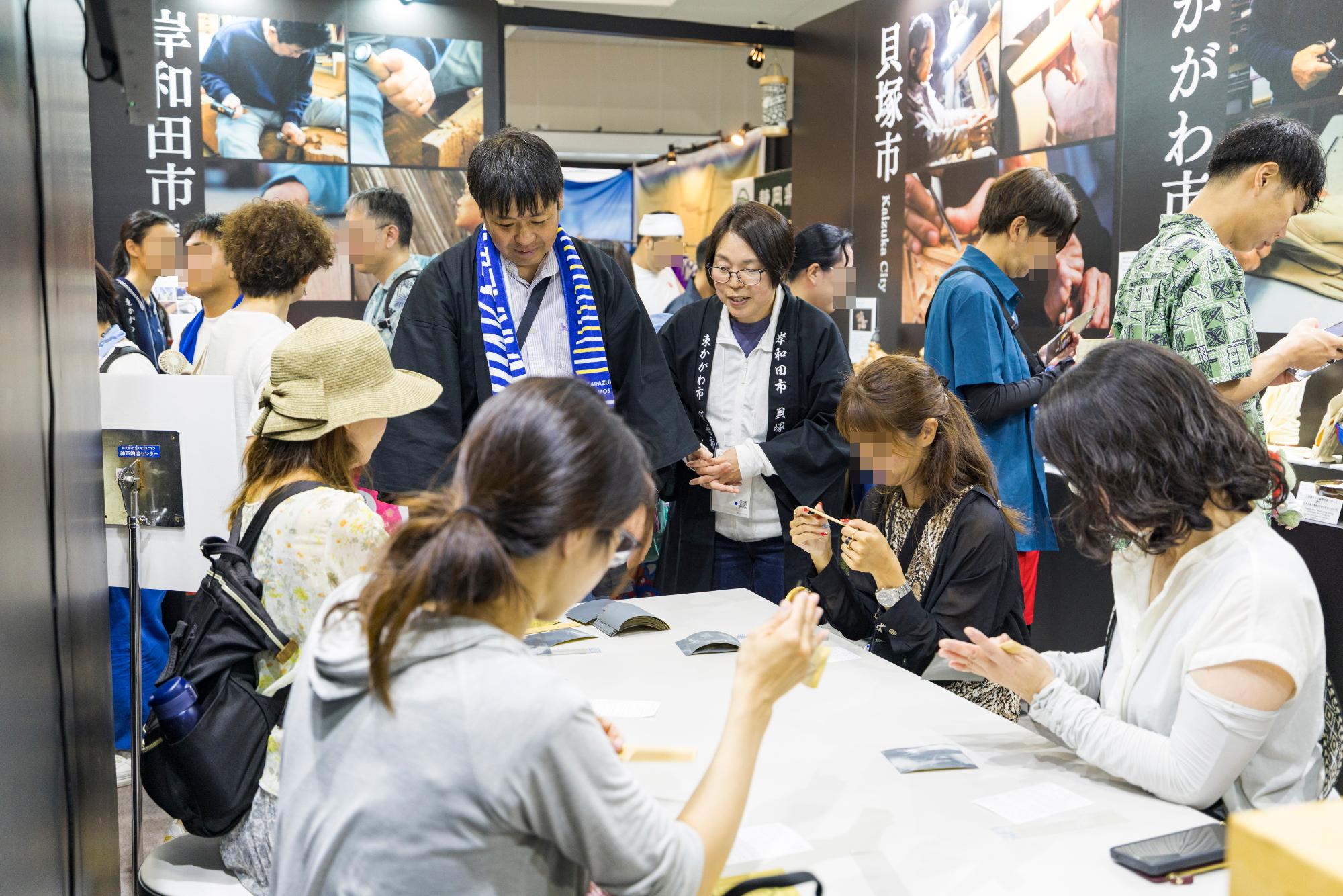 職人と来場者のつげ櫛仕上げ体験の様子