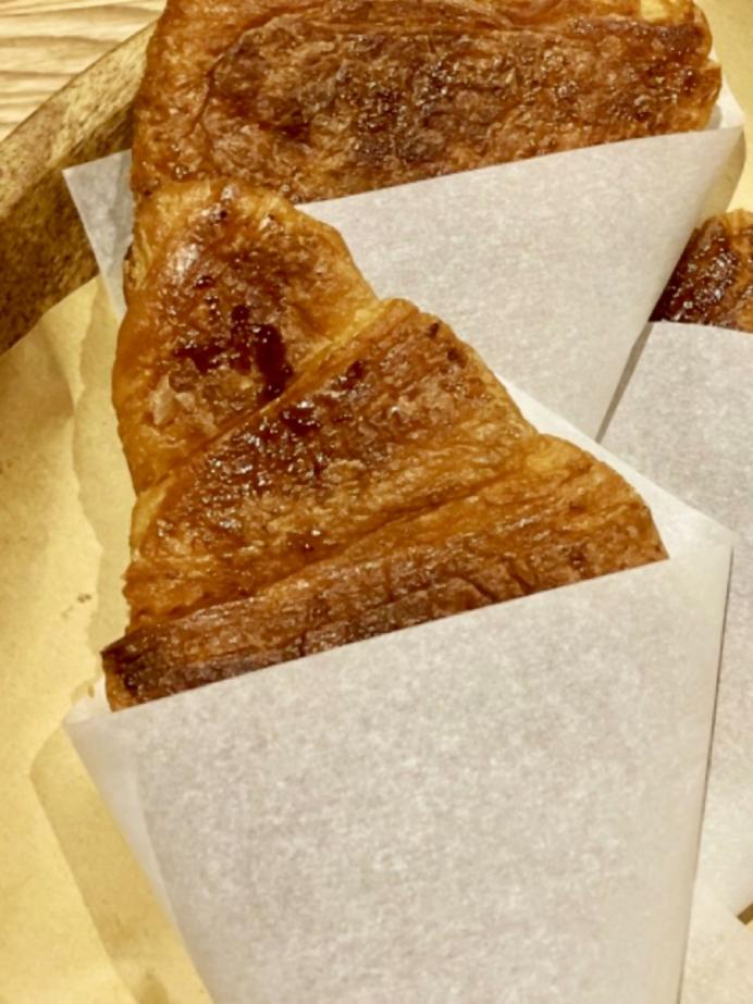 茶色いパン「クロワッサン」を平たくした「クロワッサンサンド」の写真