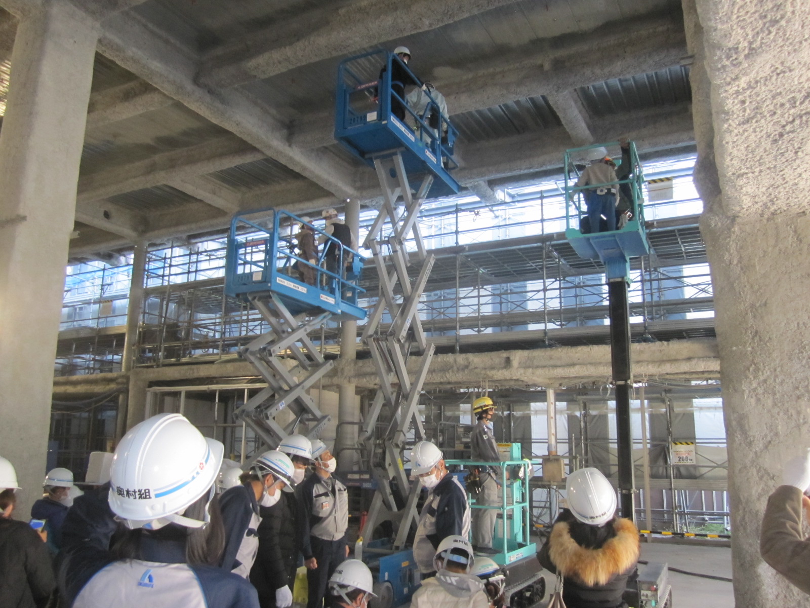 工事で使用する高所作業車に乗る体験をしている写真