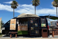 黒い車体にHassamUの看板を掲げたキッチンカー