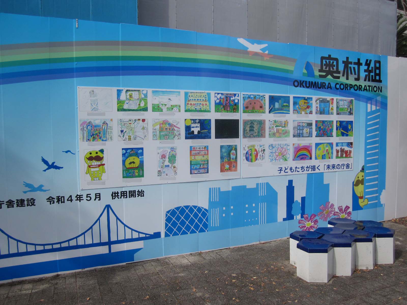 青色がベースで白いカモメが飛んでいる掲示板にたくさんのこどもたちが描いた絵が展示されている
