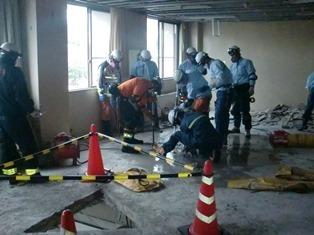 「消防突入訓練」消防士が建物の床のコンクリートを掘削しています。