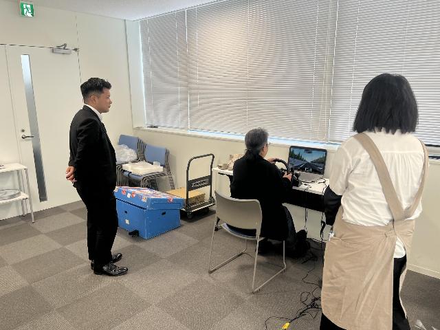 市民と市職員がシミュレーターを使用し、エコドライブ体験を行う様子。